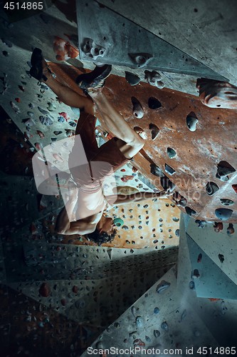 Image of Free climber young man climbing artificial boulder indoors