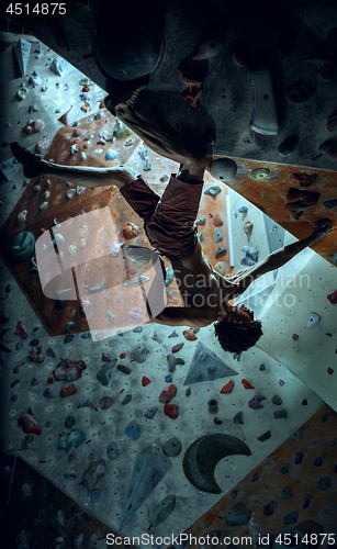 Image of Free climber young man climbing artificial boulder indoors