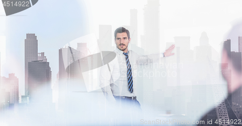 Image of Confident company leader on business meeting against new york city manhattan buildings and skyscrapers window reflection.