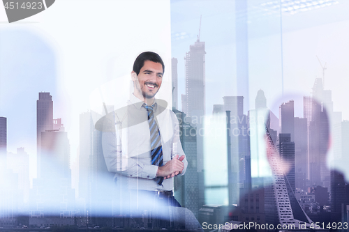 Image of Confident company leader on business meeting against new york city manhattan buildings and skyscrapers window reflection.