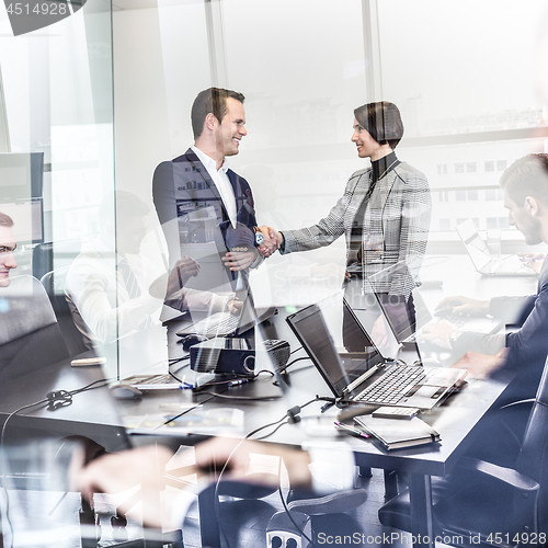 Image of Business people shaking hands in moder corporate office.