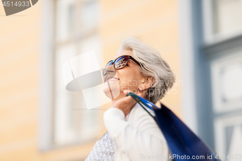 Image of senior woman in sunglasses with shopping bags