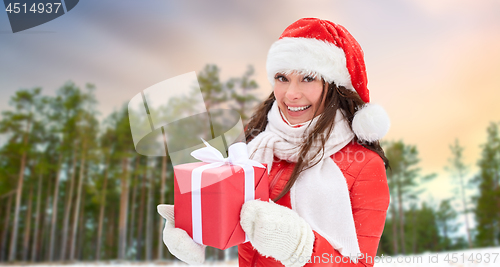 Image of woman in santa hat with chrismas gift outdoor