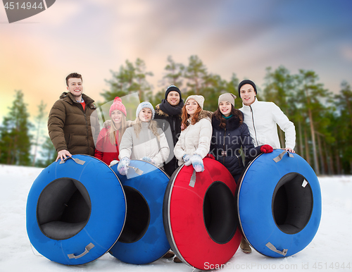 Image of happy friends with snow tubes outdoors in winter