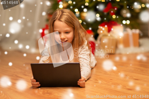 Image of smiling girl with tablet pc at christmas home