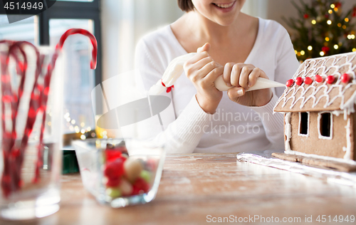 Image of woman making gingerbread house on christmas