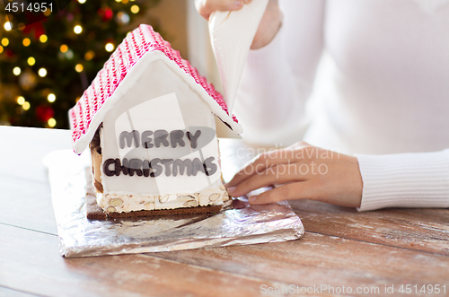 Image of woman making gingerbread house on christmas