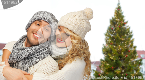 Image of happy couple hugging over christmas tree