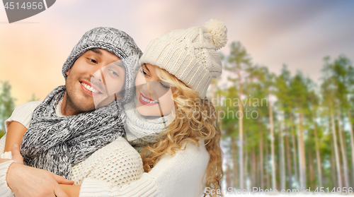 Image of couple hugging over winter forest background