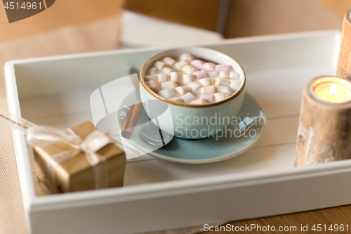 Image of hot chocolate, christmas gift and candles on table