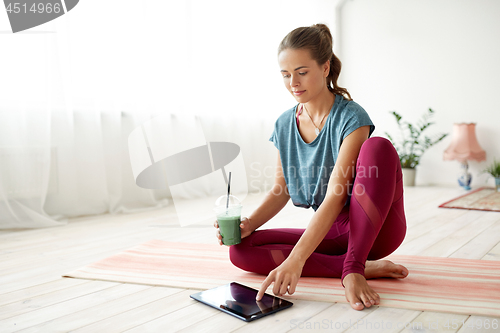 Image of woman with tablet pc and drink at yoga studio