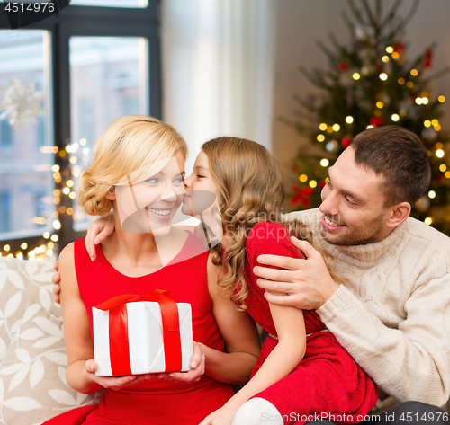 Image of happy family with christmas gift at home