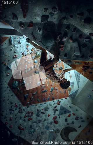 Image of Free climber young man climbing artificial boulder indoors