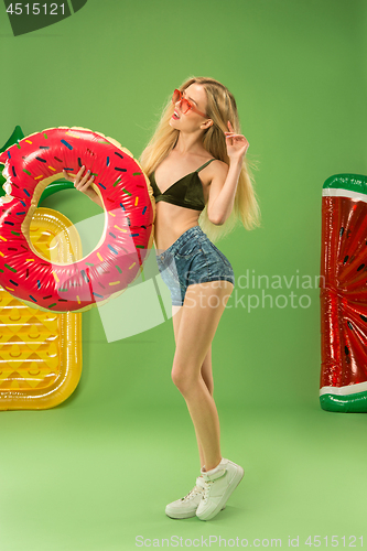 Image of Cute girl in swimsuit posing at studio. Summer portrait caucasian teenager on green background.