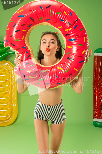 Image of Cute girl in swimsuit posing at studio. Summer portrait caucasian teenager on green background.