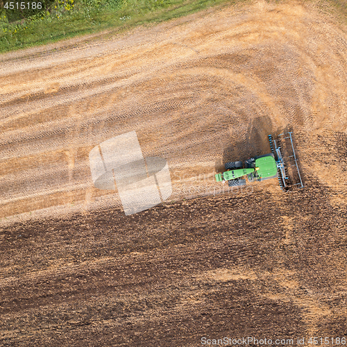 Image of The tractor plows the field, preparing the soil for agricultural work. Top view.