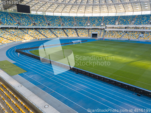 Image of KYIV, UKRAINE - July 19, 2018. NSC Olimpiysky - the inside part with a football field, tribunes and treadmills.