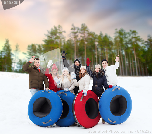 Image of happy friends with snow tubes outdoors in winter