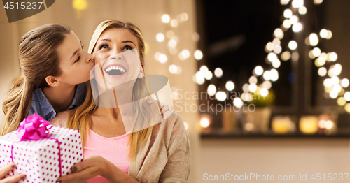 Image of daughter giving present to mother on christmas