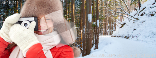 Image of happy woman with film camera over winter forest