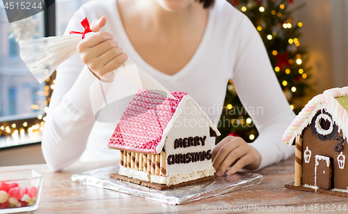 Image of woman making gingerbread house on christmas