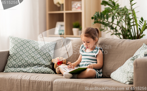 Image of little girl reading book at home