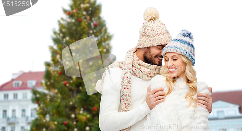 Image of happy couple hugging over christmas tree