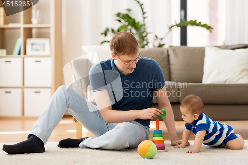 Image of happy father with little baby son playing at home