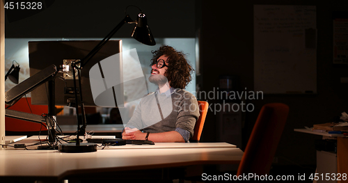 Image of man working on computer in dark office