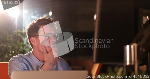 Image of man working on computer in dark office