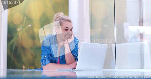 Image of young women using laptop computer on the floor