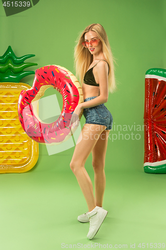 Image of Cute girl in swimsuit posing at studio. Summer portrait caucasian teenager on green background.