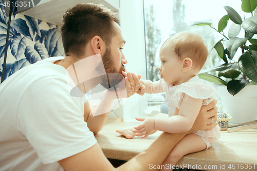 Image of The happy smiling caucasian family in the kitchen preparing breakfast