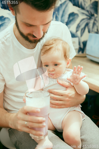 Image of The happy smiling caucasian family in the kitchen preparing breakfast