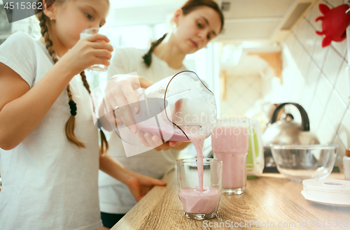 Image of The happy smiling caucasian family in the kitchen preparing breakfast