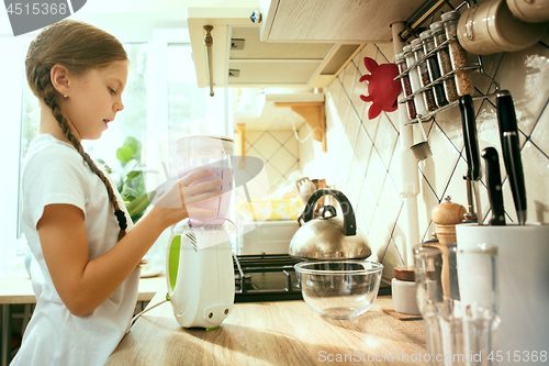 Image of The happy smiling caucasian girl in the kitchen preparing breakfast