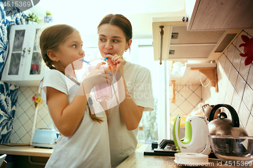 Image of The happy smiling caucasian family in the kitchen preparing breakfast