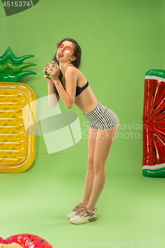Image of Cute girl in swimsuit posing at studio. Summer portrait caucasian teenager on green background.