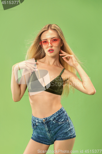 Image of Cute girl in swimsuit posing at studio. Summer portrait caucasian teenager on green background.