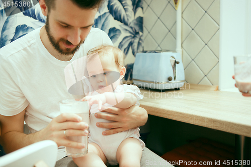 Image of The happy smiling caucasian family in the kitchen preparing breakfast