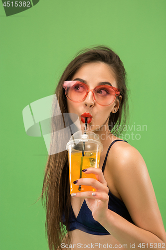 Image of Cute girl in swimsuit posing at studio. Summer portrait caucasian teenagers on green background.