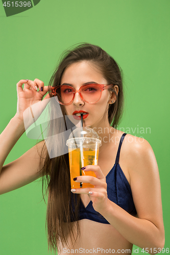 Image of Cute girl in swimsuit posing at studio. Summer portrait caucasian teenagers on green background.