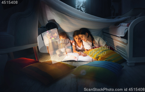 Image of A small girl and grandmother reading book at home.