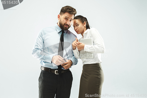 Image of The young woman whispering a secret behind her hand over white background