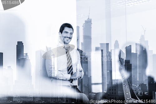 Image of Confident company leader on business meeting against new york city manhattan buildings and skyscrapers window reflections.