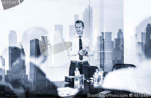 Image of Confident company leader on business meeting against new york city manhattan buildings and skyscrapers window reflection.