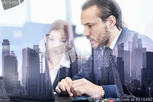 Image of Business people in modern office against new york city manhattan buildings and skyscrapers window reflections.