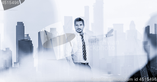 Image of Confident company leader on business meeting against new york city manhattan buildings and skyscrapers window reflection.