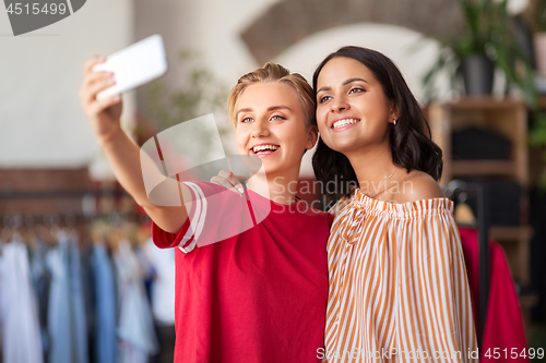 Image of female friends taking selfie at clothing store