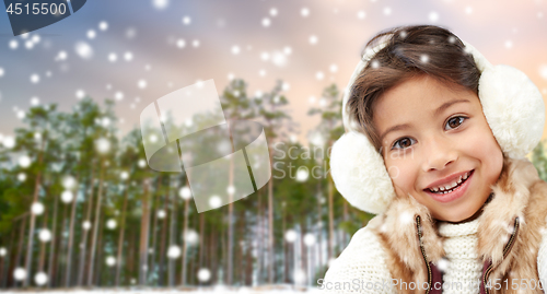 Image of little girl wearing earmuffs over winter forest